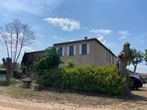 una casa con un tronco de árbol delante de ella en T3 bis bord du canal du midi piscine, en Homps