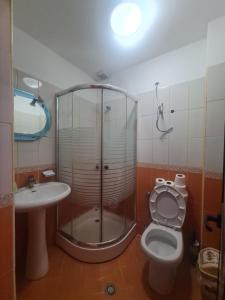 een badkamer met een douche, een toilet en een wastafel bij Hotel Kukesi in Pogradec