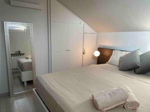 una camera da letto con un grande letto bianco e uno specchio di Confortevole appartamento in zona centrale a Torino