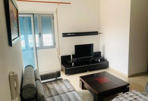 ein Wohnzimmer mit einem Sofa und einem TV in der Unterkunft H Apartment Vlorë in Vlorë