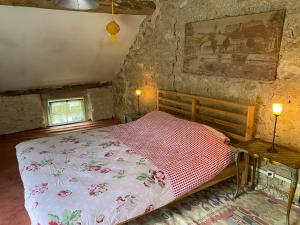 a bedroom with a bed in a stone wall at Maison L’Atelier in Thollet +4 photos