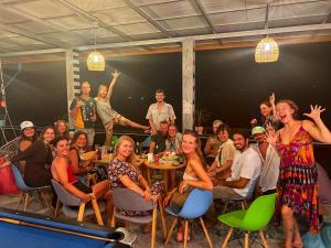 a group of people sitting around a table in a room at Wonderland Jungle Hostel in Koh Tao