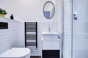 uma casa de banho branca com um lavatório e um espelho em Artsy Serviced Apartments - Ealing em Londres