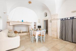 ein Wohnzimmer mit Tisch und Kamin in der Unterkunft La Casetta Bianca by BarbarHouse in Locorotondo