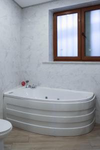 baño con bañera blanca y ventana en Piagentina Residence 1 en Florence