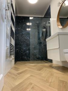 a bathroom with a shower and a wooden floor at Old Hill Residence Csopak in Csopak