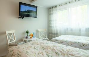 um quarto com 2 camas e uma televisão de ecrã plano na parede em Apartament Lawenda em Ciechocinek