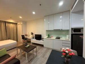 a kitchen with white cabinets and a living room at One Bukit Ceylon by Home Suites in Kuala Lumpur