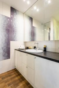 a white bathroom with a sink and a mirror at Golden Apartments Warsaw - Stylish and Luxury Apartment - Podwale in Warsaw