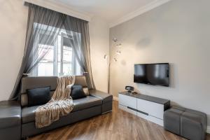 a living room with a leather couch and a flat screen tv at Golden Apartments Warsaw - Stylish and Luxury Apartment - Podwale in Warsaw