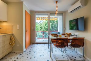 cocina con mesa y sillas y TV en Balatonic Orange, en Zamárdi