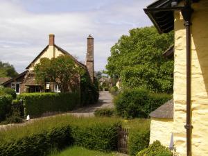 a house in a village with a chimney at Tudor Cottage in Bossington