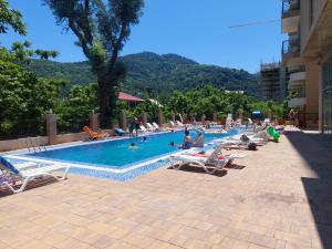 a large swimming pool with people sitting on lounge chairs at Gonio Superior in Gonio