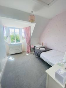 a bedroom with a bed and a desk and window at Gorgeous family home 15 mins from City Centre Edinburgh in Edinburgh