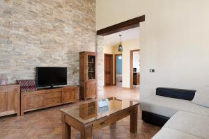 a living room with a couch and a tv at Casa Sonia y Nuria in Roche