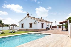 a villa with a swimming pool in front of a house at Casa Sonia y Nuria in Roche