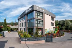 ein Hotelgebäude mit einem Spielplatz davor in der Unterkunft Hotel Siesta in Užice