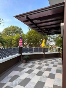 an outdoor patio with two american flags and a fence at Rumah Tamu Sonata in Seremban