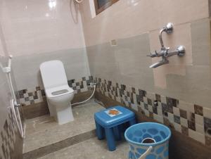 a bathroom with a toilet and a blue stool at SLS HOMESTAY - Luxury AC Service Apartments 1BHK, 2BHK, 3BHK - Direct Flyover to Alipiri Tirumala Gate - Walk to PS4 Pure Veg Restaurants, Supermarkets - Near to National Highway & Padmavathi Amma Temple - Modular Kitchen, Living room -Free Superfast Wifi in Tirupati