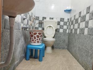 a bathroom with a toilet and a sink and a stool at SLS HOMESTAY - Luxury AC Service Apartments 1BHK, 2BHK, 3BHK - Direct Flyover to Alipiri Tirumala Gate - Walk to PS4 Pure Veg Restaurants, Supermarkets - Near to National Highway & Padmavathi Amma Temple - Modular Kitchen, Living room -Free Superfast Wifi in Tirupati