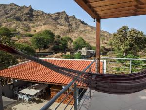 a hammock on the roof of a house with a mountain at Finca Pedra Molar in Órgãos