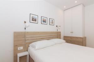 a white bedroom with a bed and two lamps at Casa Mia - Apartments & Suites in Koper