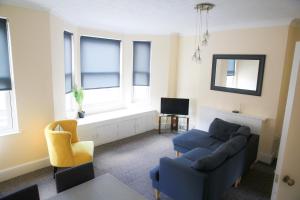 a living room with a couch and chairs and a window at Contemporary 2 Floor Flat with Sea Views! in Lowestoft