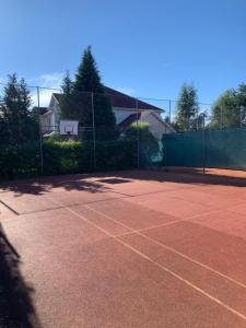 a tennis court with a basketball hoop on it at Apartament Nuldenovski Resort Grzybowo in Grzybowo +5 photos