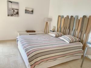 1 dormitorio con 1 cama con manta a rayas en Appartement front de mer, 80M2 (3P), Piscine & Mer, en Cannes
