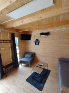a living room with a couch and a table at Tiny house toute équipée avec jardin in Saint-Florent-sur-Cher