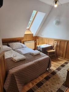 a bedroom with a bed and a desk and a window at Pokoje Gościnne Zbyszko in Zakopane