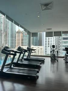 einen Fitnessraum mit mehreren Laufbändern und Stadtblick in der Unterkunft One Bukit Ceylon by Home Suites in Kuala Lumpur