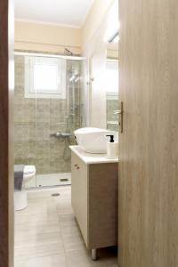 a bathroom with a sink and a toilet and a shower at Afroditi's Delux apartment in Monemvasia