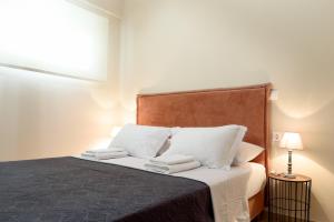 a bedroom with a bed with white sheets and pillows at Afroditi's Delux apartment in Monemvasia