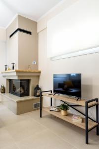 uma sala de estar com televisão e lareira em Afroditi's Delux apartment em Monemvasia