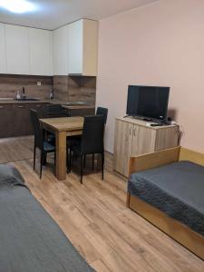 Habitación con mesa, sillas y cocina. en Cozy New Apt - Уютен апартамент en Blagoevgrado