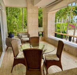 comedor con mesa de cristal y sillas en Srvittinivillas Aptla F1 Best Loc and View Lux Altos D Chavon Cdc, en La Romana