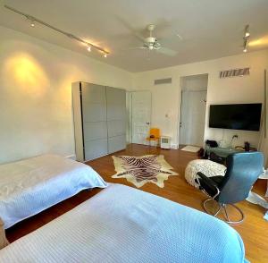 1 dormitorio con 1 cama, 1 silla y TV en Srvittinivillas Aptla F1 Best Loc and View Lux Altos D Chavon Cdc, en La Romana