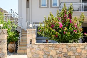 a retaining wall with flowers in front of a house at Afroditi's Delux apartment in Monemvasia