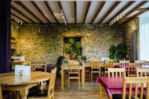 un restaurante con mesas y sillas de madera y una pared de ladrillo en Manorbier House - Lundy North Room en Tenby