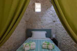 une petite chambre avec un lit avec des rideaux verts dans l'établissement Trullo nonna Pina, à San Michele Salentino 73 autres photos