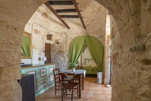 une cuisine et une salle à manger avec une table et des chaises dans l'établissement Trullo nonna Pina, à San Michele Salentino