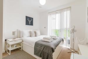 a white bedroom with a bed and a window at Gorgeous Wembley Flat in London