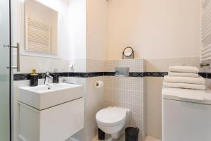 a white bathroom with a toilet and a sink at Golden Apartments Warsaw - Big Luxury Apartment in the Center - Kolejowa in Warsaw