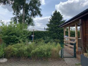 un jardín con sombrilla y puerta en Carla am Strand, en Garrel