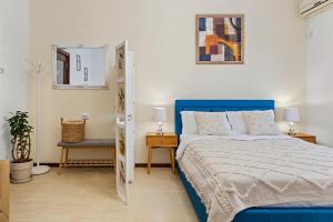 a bedroom with a blue bed and a mirror at Upscale Studio, Walking Distance from The Old Town in Bucharest