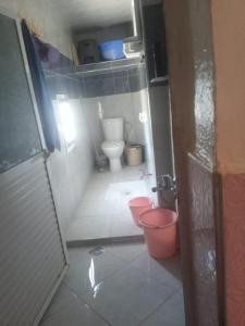 a small bathroom with a toilet and two buckets at شقة للكراء اليومي في شفشاون in Chefchaouen