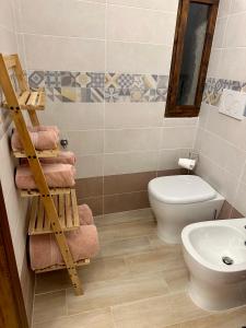a bathroom with a toilet and a sink and towels at All’ombra del museo in Tarquinia
