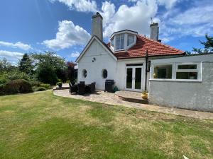 a white house with a lawn in front of it at Gorgeous family home 15 mins from City Centre Edinburgh in Edinburgh