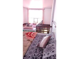 una camera da letto con letto, cuscini e finestra di The Views - True Baduaga Living a Ooty